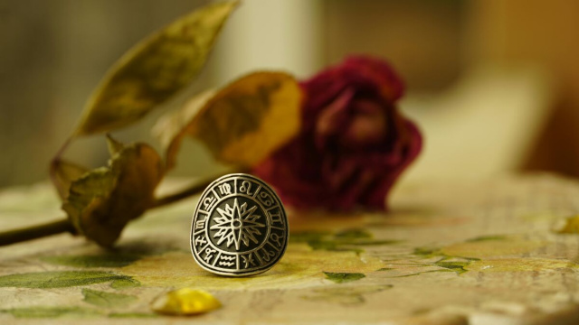 Anello con segni zodiacali e rosa sullo sfondo- Pexels
