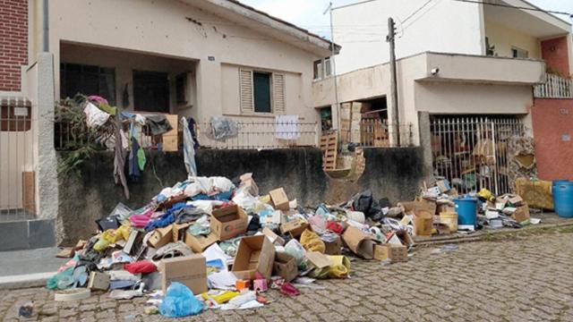 Mulher acumula lixo por mais de 20 anos e marido tem que quebrar muro para entrar em casa